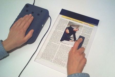 Bild: Eine Hand liegt auf dem VideoTIM1, die andere f�hrt die kleine Hand-Videokamera